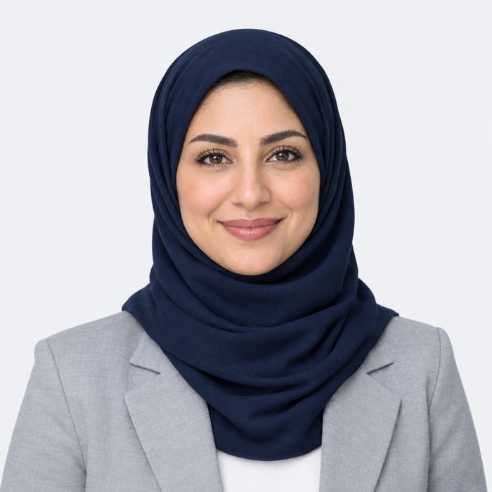 Smiling woman in a navy hijab and grey blazer
