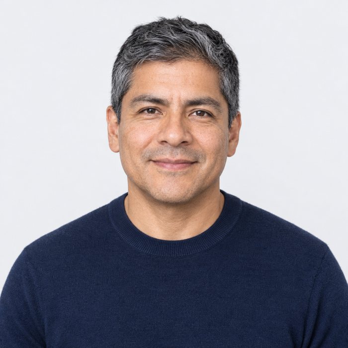 Smiling man with salt-and-pepper hair in a navy sweater